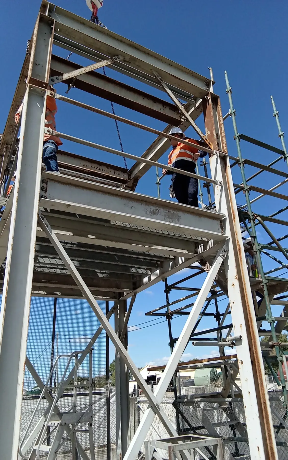 Trainees in harnesses working on the platform of the steel training tower